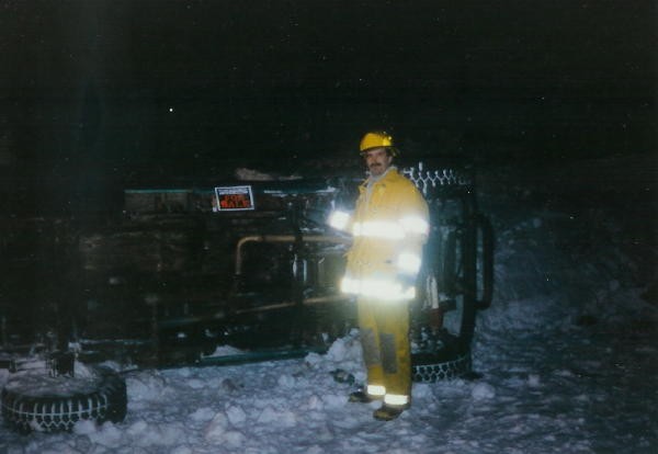 Firefighter Jeff Lawrence posing with an overturned Jeep.