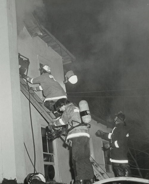 Firefighter Mike Nelson donning an SCBA at a House Fire on Roney's Corner Road.