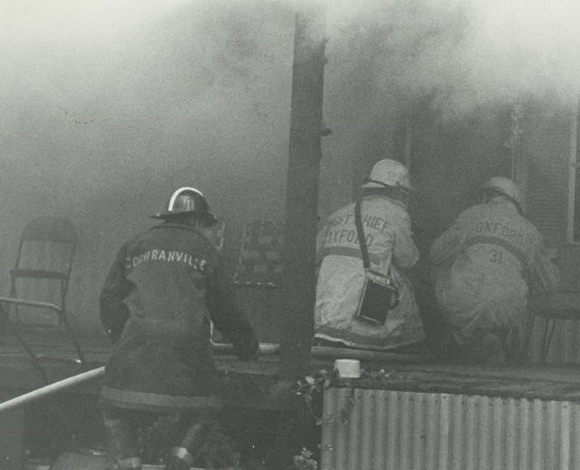 Crews making entry at a mobile home fire.