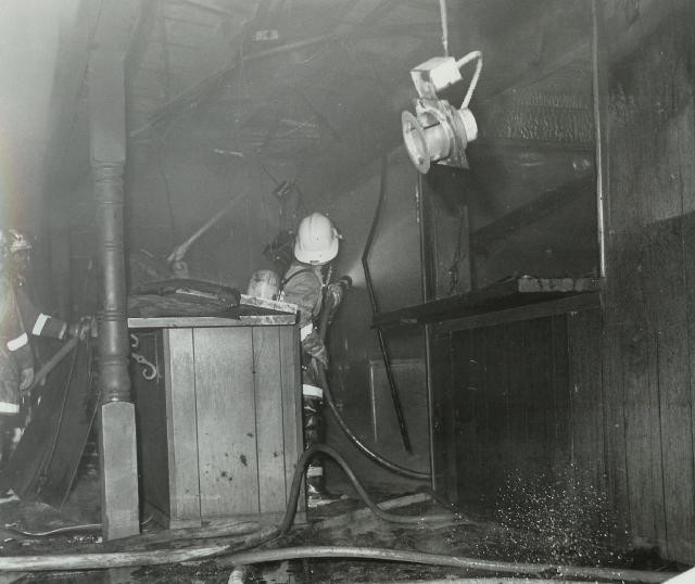 Firefighter Jane Brown operates a handline at the Oxford Drive-In fire.