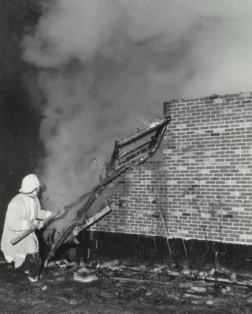 A firefighter pulls down a wall at the Scarfo's Restaurant fire in Nottingham.