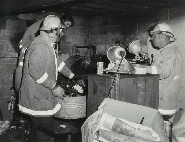 Chief Terry talks with firefighters Jim Nelson and Bob Riley in the basement of a house fire.