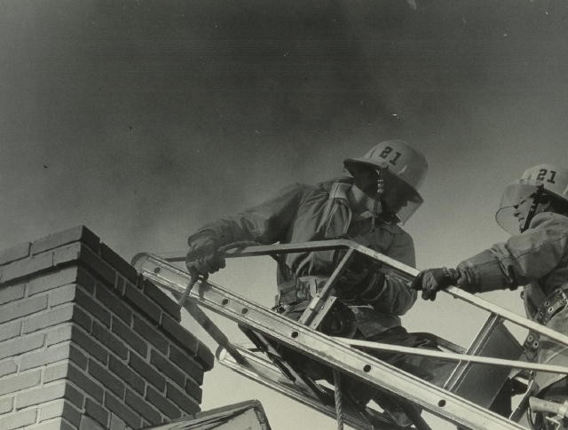 Ladder crew working off of the tip with chains at a chimney fire.
