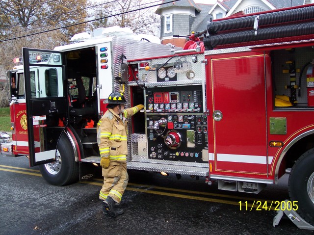 Past Chief Lonnie Brown pumping Engine 1 on a Pine Street house fire.