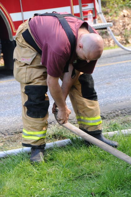 Firefighter Mark Vining rolling hose.