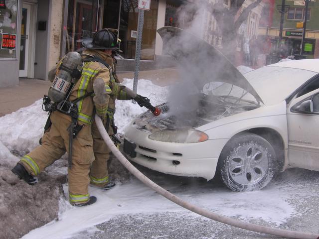 Lieutenant Bill Hensel and Firefighter Candace Patrick attacking a Market Street car fire.