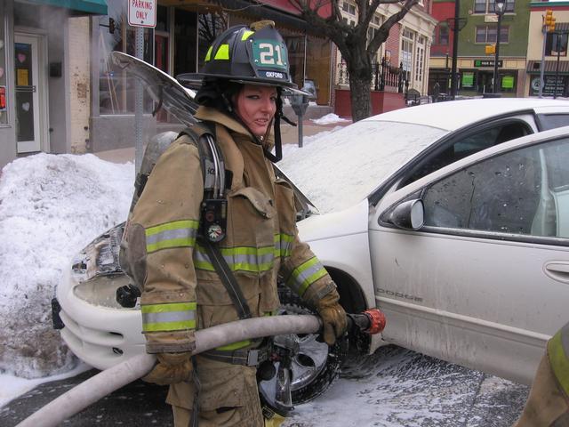 Firefigher Candace Patrick operates at a car fire on Market Street.