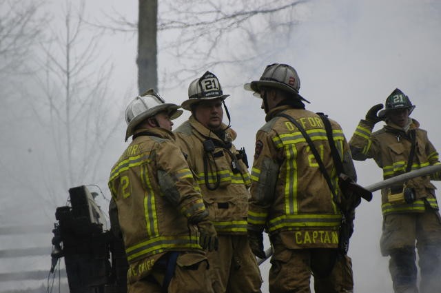Chief Obenchain, Assistant Chief Terry, and Captain Slauch conversing at an Elk Township house explosion.