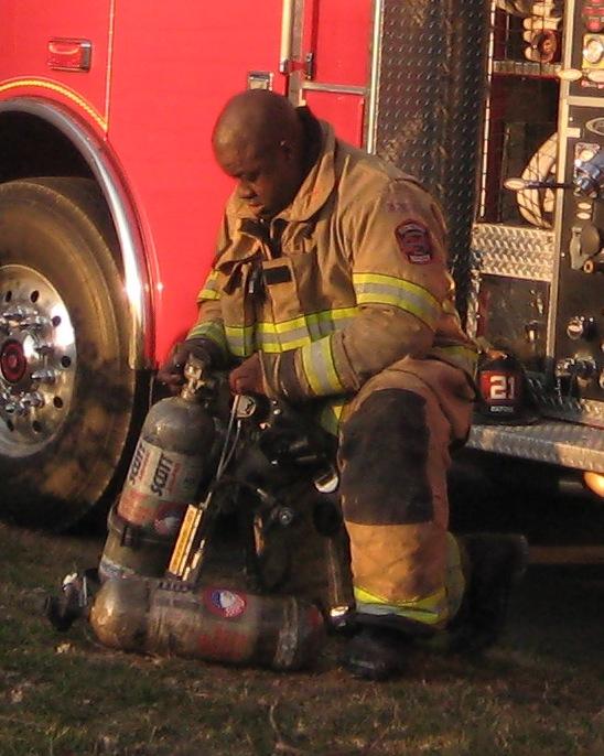 Firefighter Tim Greene swapping cylinders at a first due house fire.